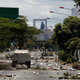 A Bolivarian National Guard vehicle drives down a barren street during a clash between opposition protesters and the Bolivarian National Guard